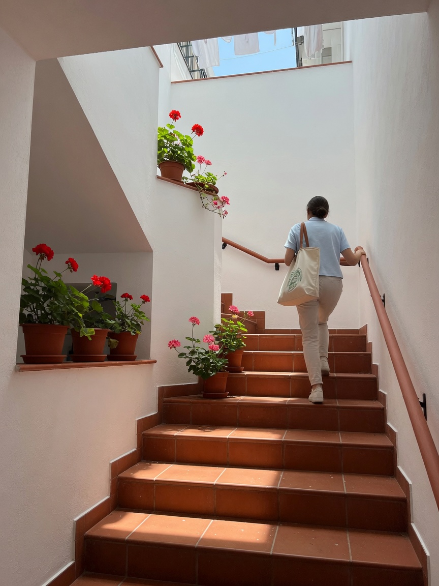 Arriving at a home in Granada: a figure seen from behind climbing tiled stairs, carrying the bag of test material.