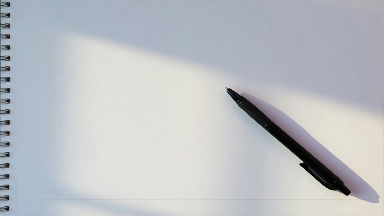 A blank page and a pen, seen close up.
